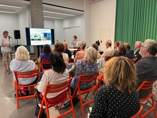 People sitting watching a presentation in a large room